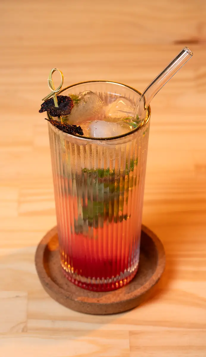 Bebida de frutos rojos con hierbabuena en vaso estriado